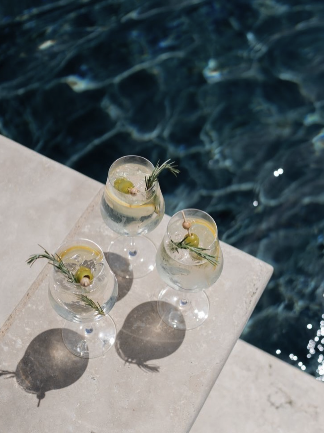 Crisp gin cocktails with rosemary by the water
