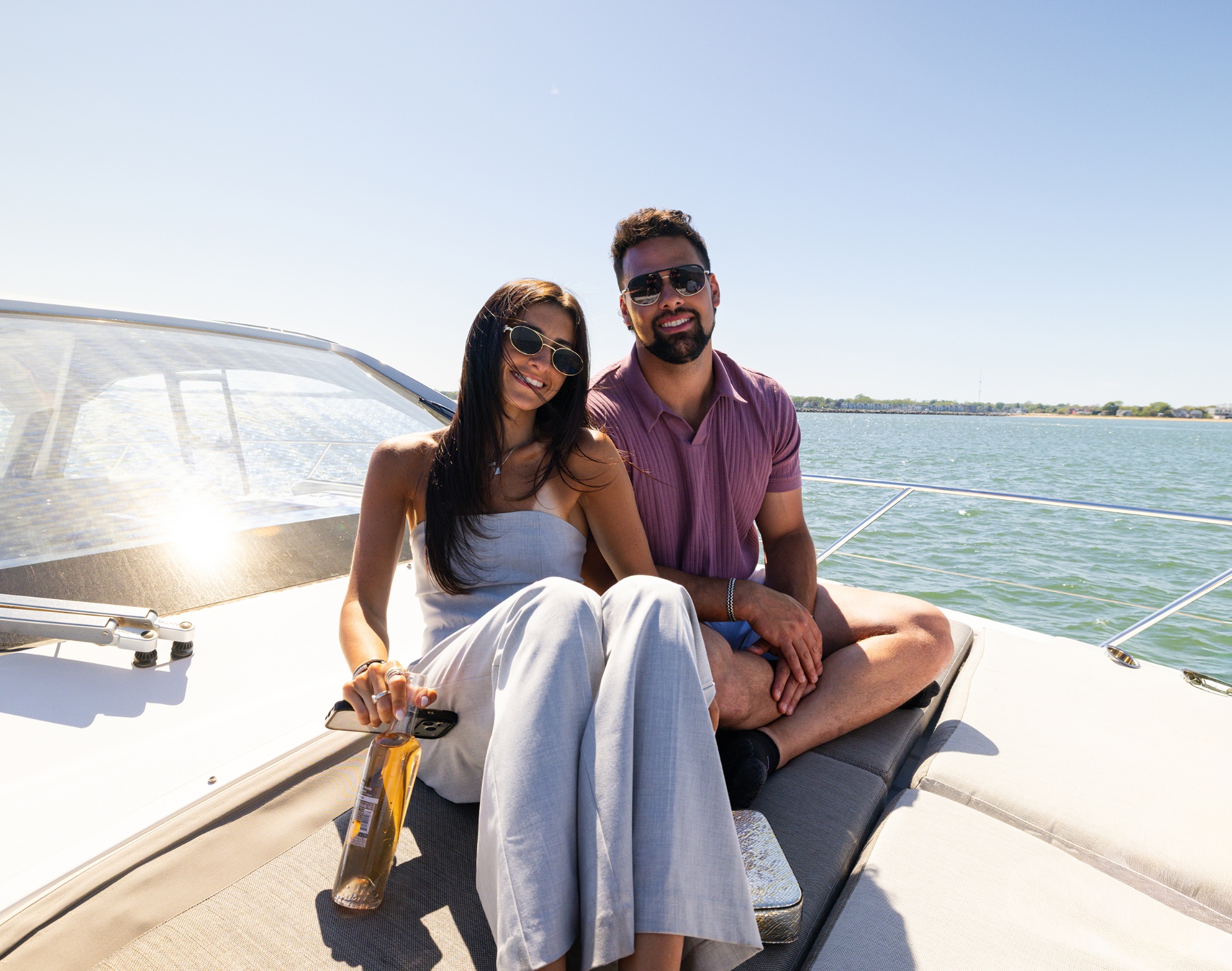 Couple enjoying drinks on the bow of a yacht